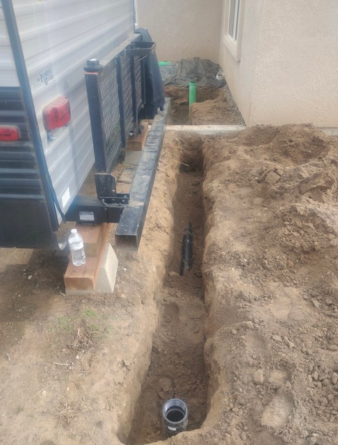 Water line trench dug alongside a structure